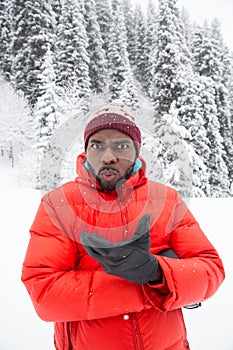 African American Cheerful black man in ski suit in snowy winter outdoors, Almaty, Kazakhstan