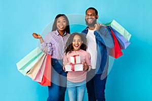 African American cheerful people holding shopping bags and gift