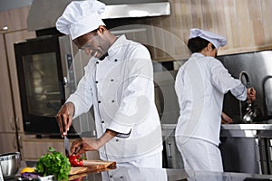 african american chef cutting bell pepper