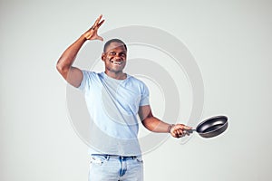 African american chef kitchener holding a frying pan wizard man cooking magic flying food salad, carrot, garlic, onion