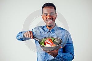 African american chef kitchener holding a frying pan wizard man cooking magic flying food salad, carrot, garlic, onion