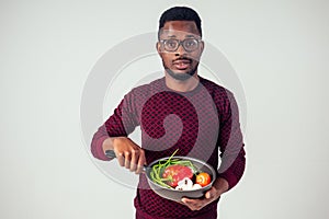 African american chef kitchener holding a frying pan wizard man cooking magic flying food salad, carrot, garlic, onion