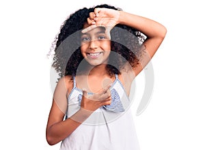 African american child with curly hair wearing casual clothes smiling making frame with hands and fingers with happy face