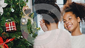 African American child decorated with ornament on Christmas tree at Christmas and New Year festival at home. Xmas celebration