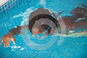 African American child with goggles in the pool