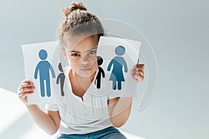 African american child holding ripped paper with family on white