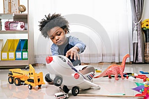 African American child play truck and airplane toy at home