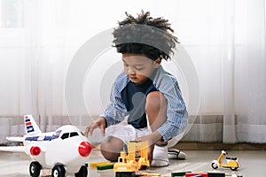 African American child play truck and airplane toy at home