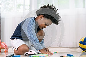 African American child play truck and airplane toy at home