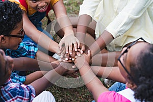 African American children have fun sitting join hands together in the park