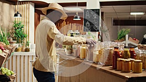 African american client shopping for pasta or grains in jars