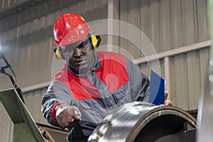 African American CNC Machine Operator Monitoring The Train Wheel Manufacturing Process On Lathe Machine