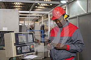 African American CNC Machine Operator In Protective Workwear Checking Measurements With Vernier Caliper