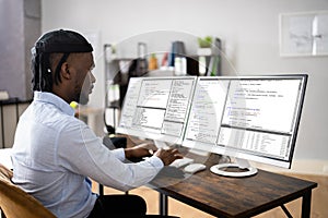 African American Coder Using Computer At Desk