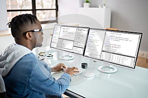 African American Coder Using Computer At Desk