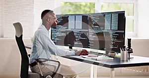 African American Coder Using Computer At Desk photo