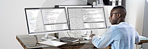 African American Coder Using Computer At Desk