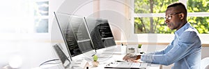 African American Coder Using Computer At Desk