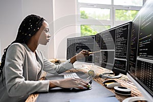 African American Coder Using Computer At Desk