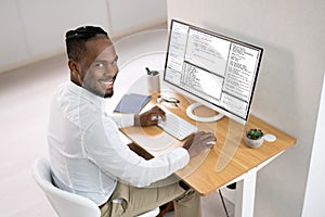 African American Coder Using Computer At Desk