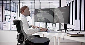 African American Coder Using Computer At Desk