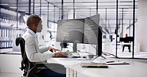 African American Coder Using Computer At Desk
