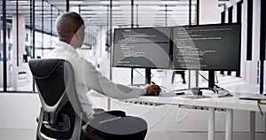 African American Coder Using Computer At Desk