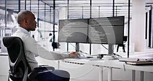 African American Coder Using Computer At Desk