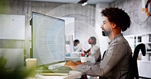 African American Coder Using Computer At Desk