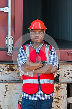 African American Container Warehouse Worker. Foreman control loading Containers box from Cargo freight ship for import export.