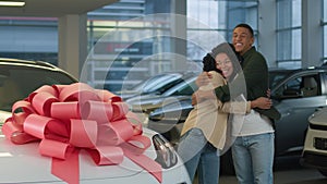 African American couple boyfriend girlfriend in dealership showroom surprise new crossover car gift birthday present