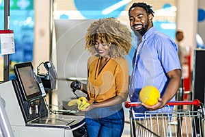 African American Couple buying food at grocery store or supermarket self-checkout