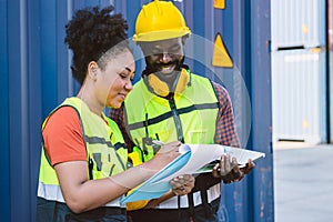 African American couple customs team staff worker working together with check list shipping order at port container yard enjoy