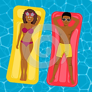 African american couple floating on inflatable mattresses in swimming pool