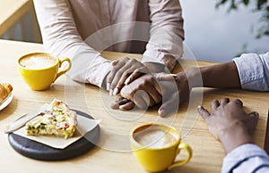 African American couple holding hands together at table in cafe, close up