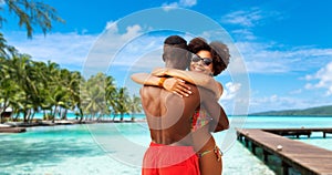 African american couple hugging on summer beach