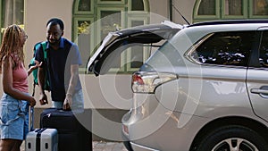 African american couple loading voyage luggage in car