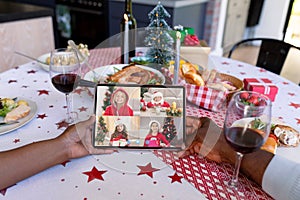 African american couple making tablet christmas video call with four smiling caucasian girls