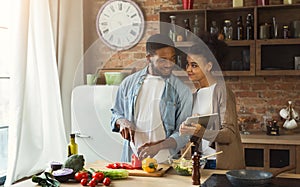 African-american couple searching for recipe using digital tablet