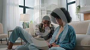 African American couple sit on floor at home living room woman girl wife upset sad suffer problem with laptop computer