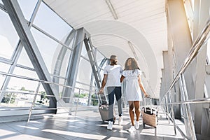 African-american couple travelers with suitcases at airport