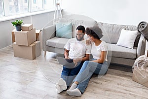 African American Couple Using Laptop After Moving In New House