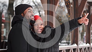 African American couple in warm clothes walking in the winter city together