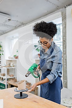 African american craftswoman holding heat gun