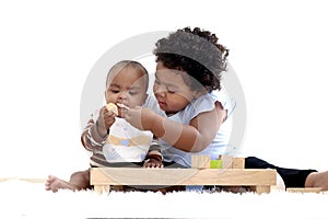 African American curly hair girl trying to feed her little sister with spoon of food, infant eating healthy homemade baby food,