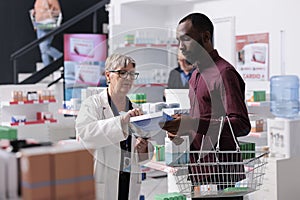 African american customer talking with pharmacist asking for help with cardiology pills