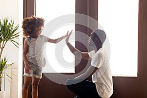 African American dad give high five to small daughter