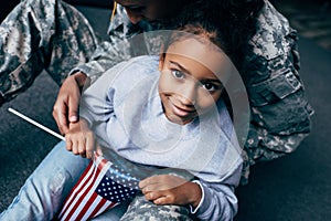 african american daughter and female soldier in military uniform with american flag