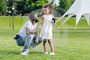 african american daughter holding father police badge