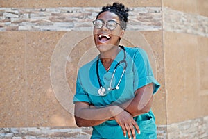 African american doctor female at lab coat with stethoscope posed outdoor against clinic